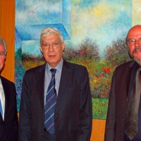 Schmückt mit seinem Gemälde die Uni: Mario Diaz Suarez (Mitte) mit Helmut Schröer (links) und Peter Schwenkmezger (rechts) - 5VIER