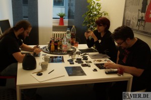 Spieltester Kenneth (links) Schappo, Jasmin Thomé (hinten rechts) und Spieldesigner René Müller am Spieltisch. Foto:Lars Eggers