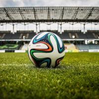 Ein Fussball liegt auf dem Mittelpunkt im Stadion. Foto: jarmoluk - pixabay.com