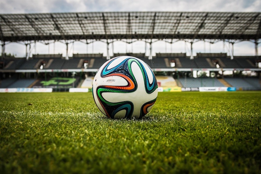 Ein Fussball liegt auf dem Mittelpunkt im Stadion. Foto: jarmoluk - pixabay.com
