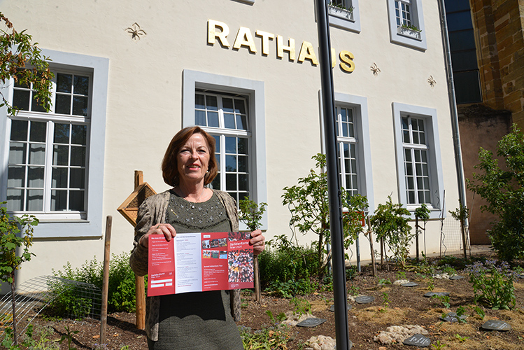 Bürgermeisterin Elvira Garbes präsentiert den Info-Flyer für die Solidarkarte vor dem Trierer Rathaus. Foto: Presseamt Trier