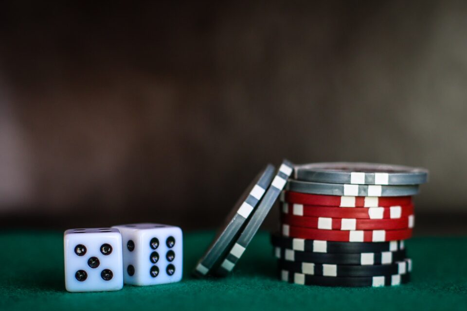 Foto zeigt 2 Würfen und Pokerchips auf einem Tisch. - Foto: Heather Gill / unsplash.com