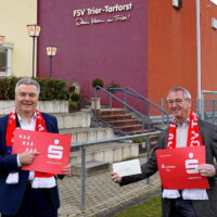 Das Foto zeigt den Vereinsvorsitzenden Werner Gorges (rechts) und Wolfgang Ziewers von der Sparkasse Trier (links) bei der Spendenübergabe vor dem Sportzentrum
