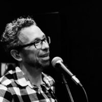 Das Bild zeigt den Musiker Johannes Schier am Mikrofon . Foto: Merrin Bydder