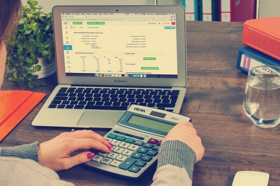 Das Foto zeigt jemanden, der vor einem Notebook mit einem Taschenrechner etwas berechnet. Foto: Pixabay
