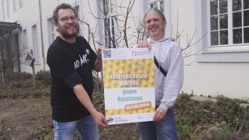  "Wim Negelen und Tom Cartus vom Rassismuskritischen Netzwerk mit dem Plakat der diesjährigen Veranstaltungsreihe der Internationalen Wochen gegen Rassismus in Trier" (Foto: Mechthild Schneiders)
