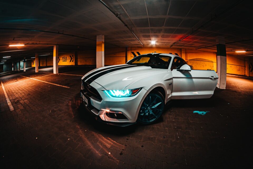 Ein geparkter Ford Mustang in der Tiefgarage mit offener Fahrertür und eingeschaltetem Licht. Foto: Foto von Jan Kopřiva von Pexels