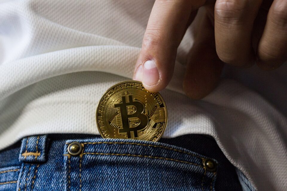 Eine Bitcoin Münze wird auf der Hosentsche gezogen. Foto: www.pexels.com worldspectrum 