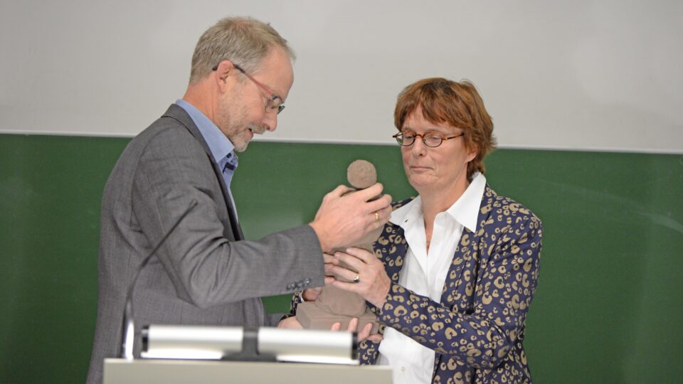 Prof. Dr. Torsten Mattern, Vizepräsident der Universität, übergibt die Ausonius-Statuette an Preisträgerin Prof. Dr. Irene de Jong. Foto: Universität Trier.