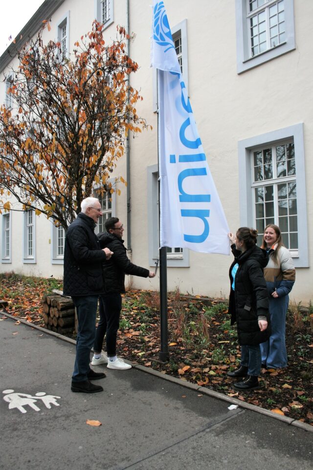 Flagge zeigen vor dem Rathaus: Oberbürgermeister Wolfram Leibe und die UNICEF Trier Mitglieder ziehen nicht nur beim Hissen der UNICEF-Flagge an einem Strang. Foto: 5vier,de