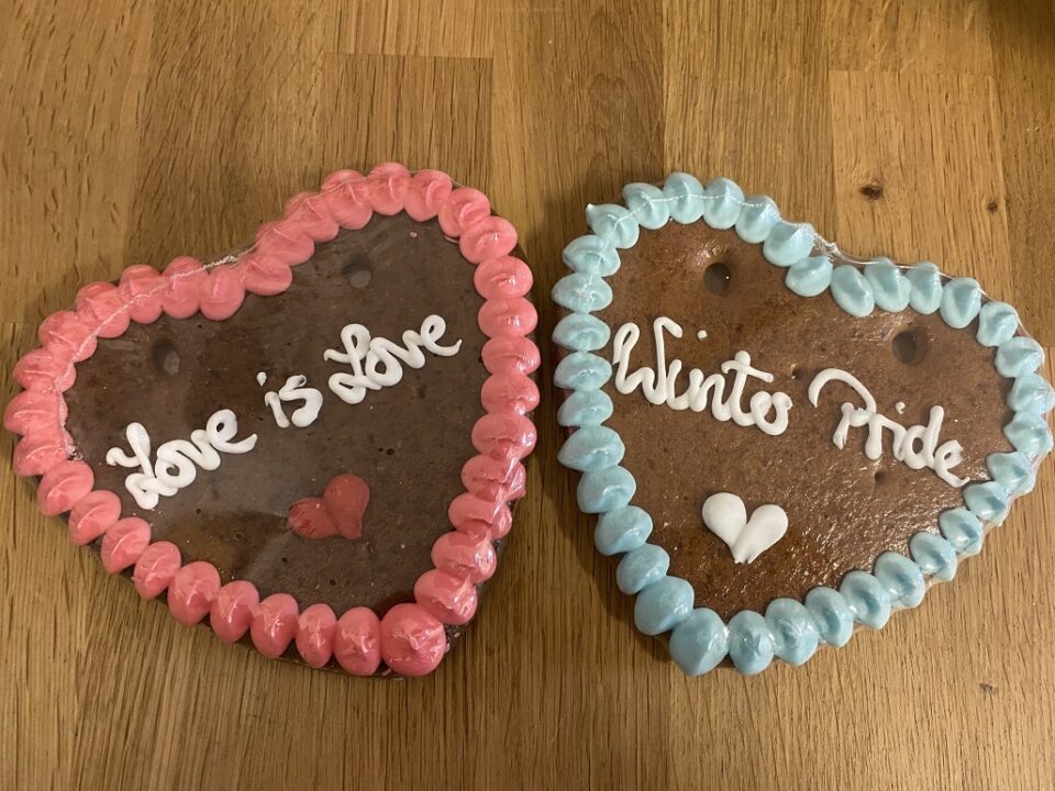 Zu sehen sind zwei Lebkuchenherzen: Ein rot umrandetes mit der Aufschrift „Love is Love" und ein blau umrandetes mit der Aufschrift „Winter Pride". Foto: Alex Rollinger/ SCHMIT-Z e.V.
