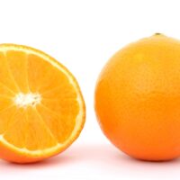 Das Bild zeigt eine Gnaze Orange auf der rechten Seite, links daneben befindet sich eine halbe Orange. Foto: Pixabay/ Pexels