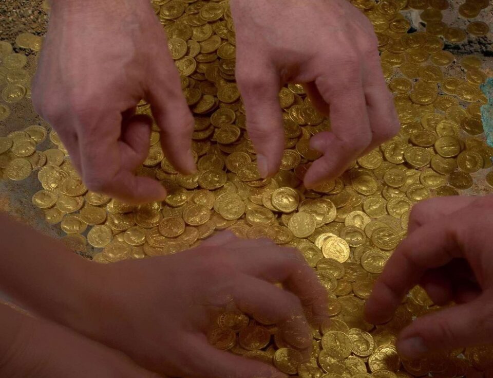 Hände, die nach Goldmünzen greifen. Foto: Th Zühmer
