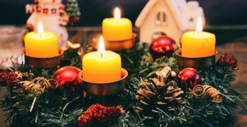 Vier gelb beleuchtete Kerzen eines Weihnachtskranzes. Bild: Pexels/ Pixabay