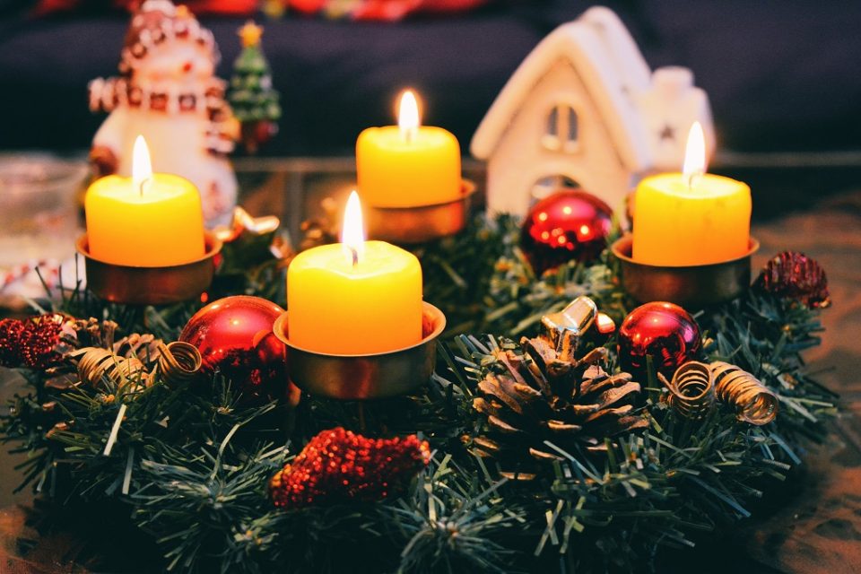 Vier gelb beleuchtete Kerzen eines Weihnachtskranzes. Bild: Pexels/ Pixabay