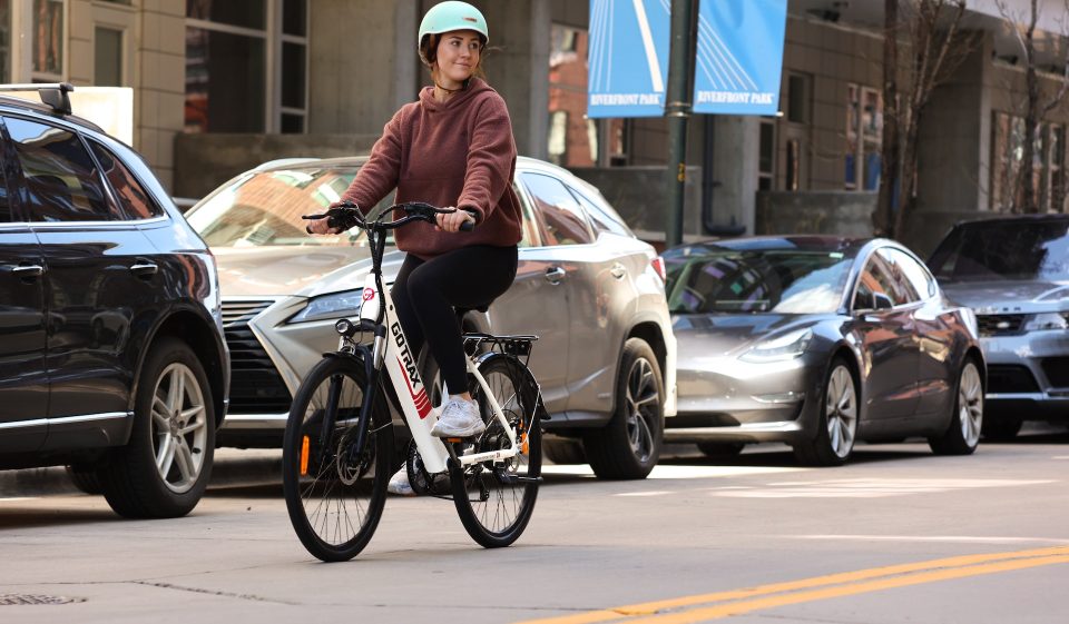 Frau fährt Farrahd in der Innenstadt mit Helm. Foto: Gotrax auf Unsplash